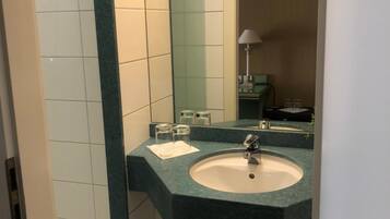 A bathroom with a sink, mirror, and toilet.