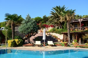 Una piscina al aire libre, tumbonas