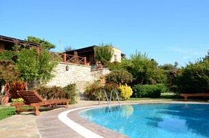 Una piscina al aire libre, tumbonas