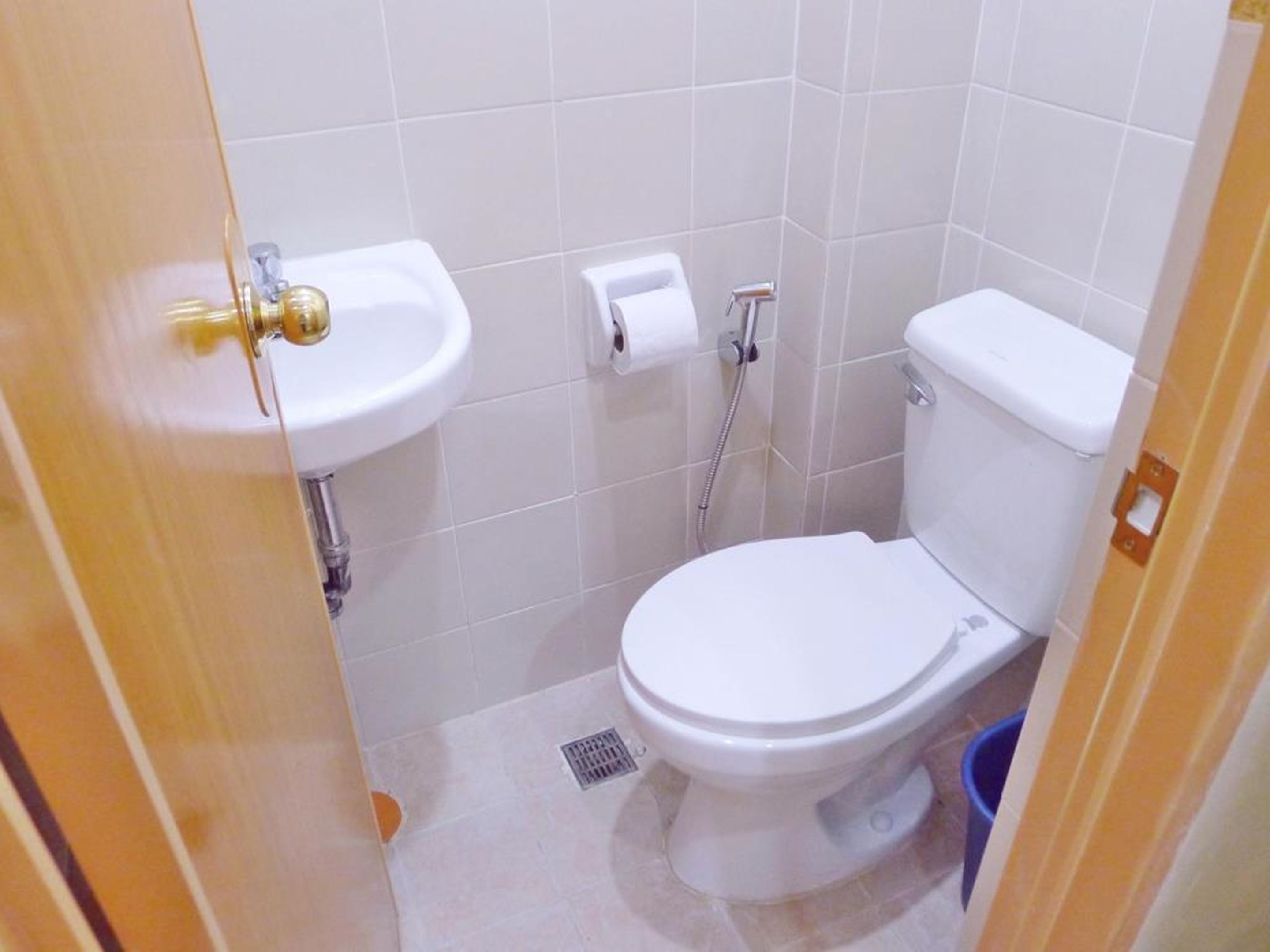 Un baño pequeño y limpio con inodoro blanco, lavabo y ducha.