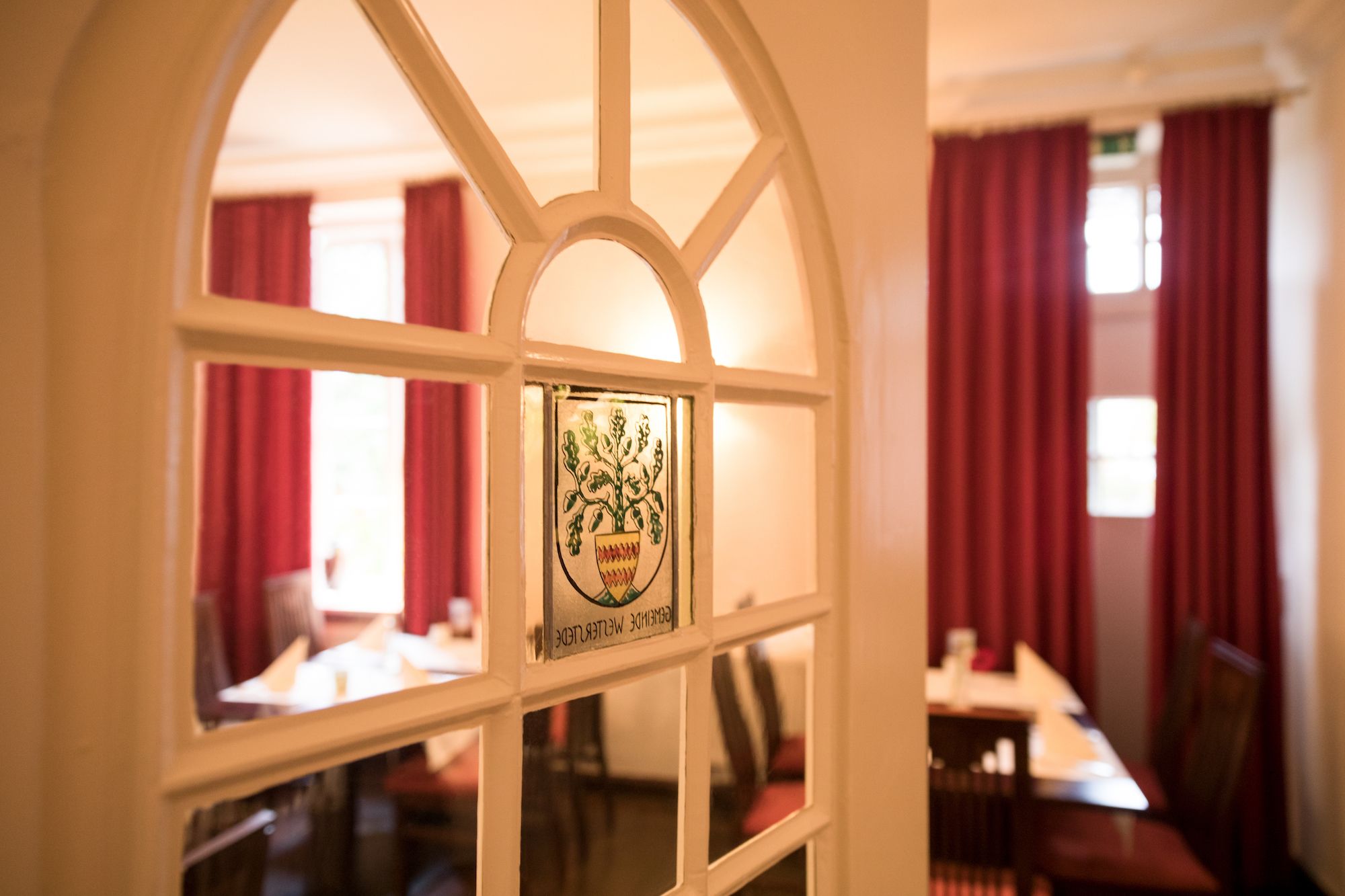 Een restaurantinterieur met een raam waarop een logo en naam staan.