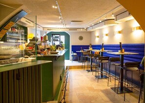 Enjoy a meal at our restaurant, where a bar area with a glass display case and comfortable seating await.