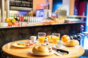 Una mesa de desayuno con cruasanes, zumo de naranja y un cuchillo.