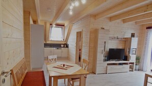 Un intérieur en bois comprenant un coin repas, une cuisine et un espace de vie.