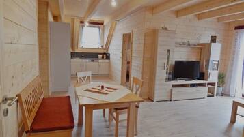 A wooden interior with a dining area, kitchen, and living space.