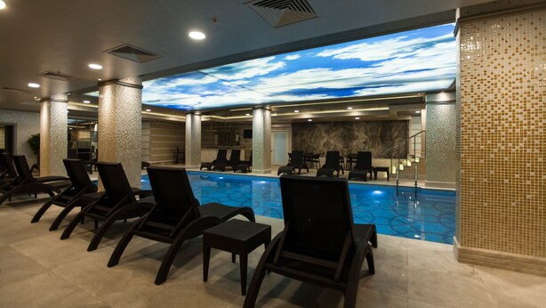 A pool area with lounge chairs and a ceiling mural. - Miss Istanbul Hotel & Spa (Istanbul)