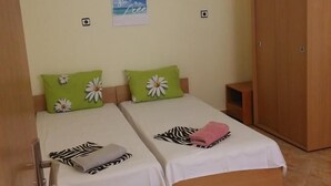 A bedroom with two beds, a wardrobe, and a wall-mounted picture. - Varna Apartments (Varna)