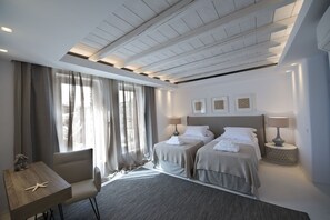 Une chambre d’hôtel moderne avec deux lits, un bureau et une chaise.