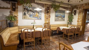 Ein Restaurant mit Steinsälen, Holzmöbeln und hängenden Pflanzen.