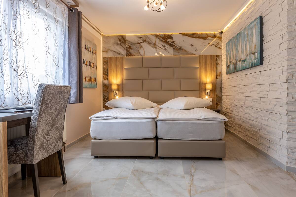 A bedroom with a double bed, a desk, and a chair.