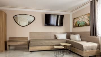 A modern bedroom with a sofa bed, a TV, a painting, and a small table.