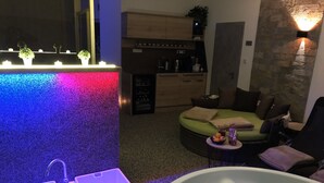 Uma casa de banho moderna com uma banheira grande, duas pias e um detalhe de parede colorido.