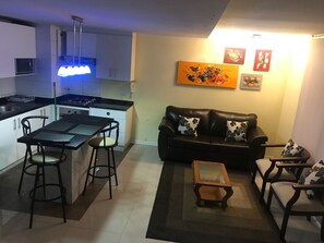 Leilighet, 2 soverom, privat bad | Oppholdsområde | En 32-tommers LED-TV med kabel-kanaler samt TV