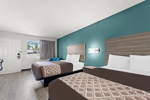 A hotel room with two beds, a desk, a chair, a window, and a door. - Rodeway Inn Cairo (Cairo)