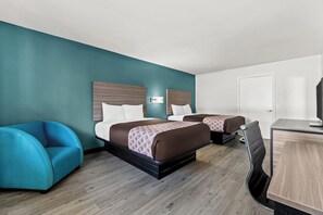 A hotel room with two beds, a desk, a chair, and a door. - Rodeway Inn Cairo (Cairo)