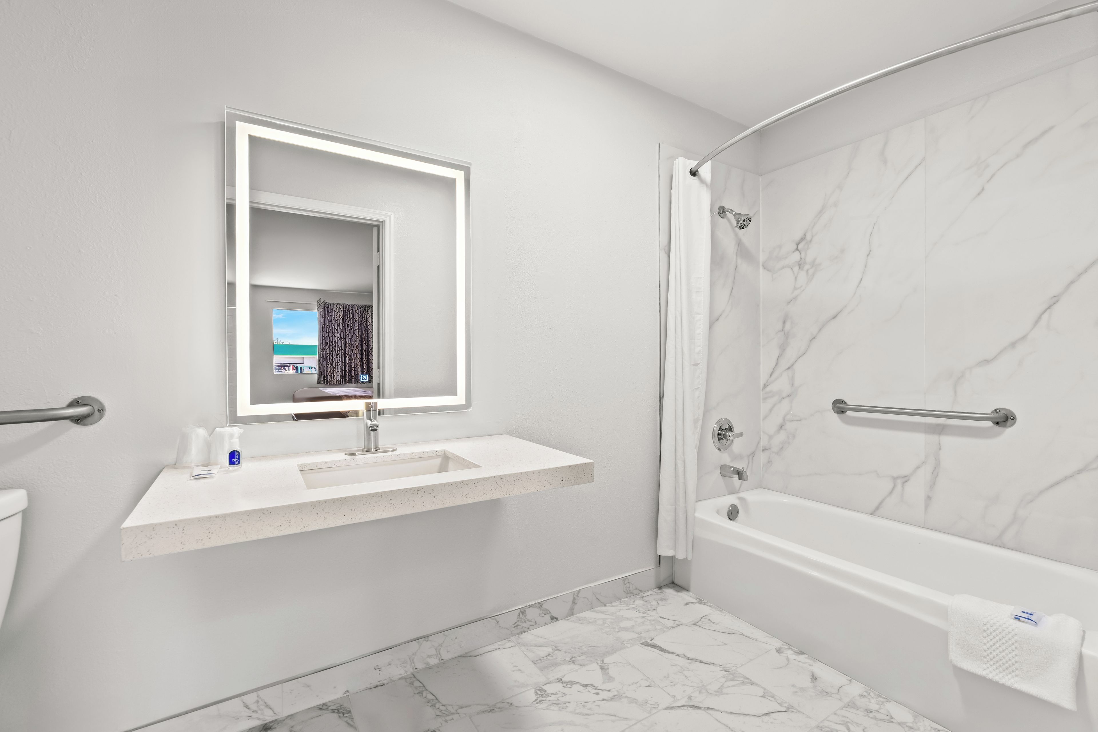 Ein modernes Badezimmer mit Waschbecken, Spiegel und Badewanne.