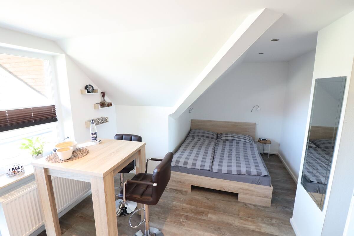 A compact bedroom with a bed, a desk, and a chair.