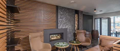 A modern interior with a fireplace, leather seating, and a stone accent wall.