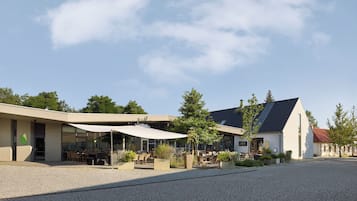 A building with outdoor seating and a cobblestone courtyard.