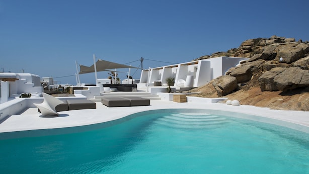 A modern pool area with white architecture and a clear blue pool. - Amethyst Suite (Mykonos)