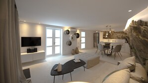 A modern living room with a sofa, a coffee table, and a dining area with chairs and a table. There is a TV mounted on the wall and a kitchen area with a refrigerator. - Amethyst Suite (Mykonos)