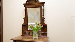 A wooden cabinet with a mirror and a vase of flowers. - Kleine Villa Rose (Eltville am Rhein)