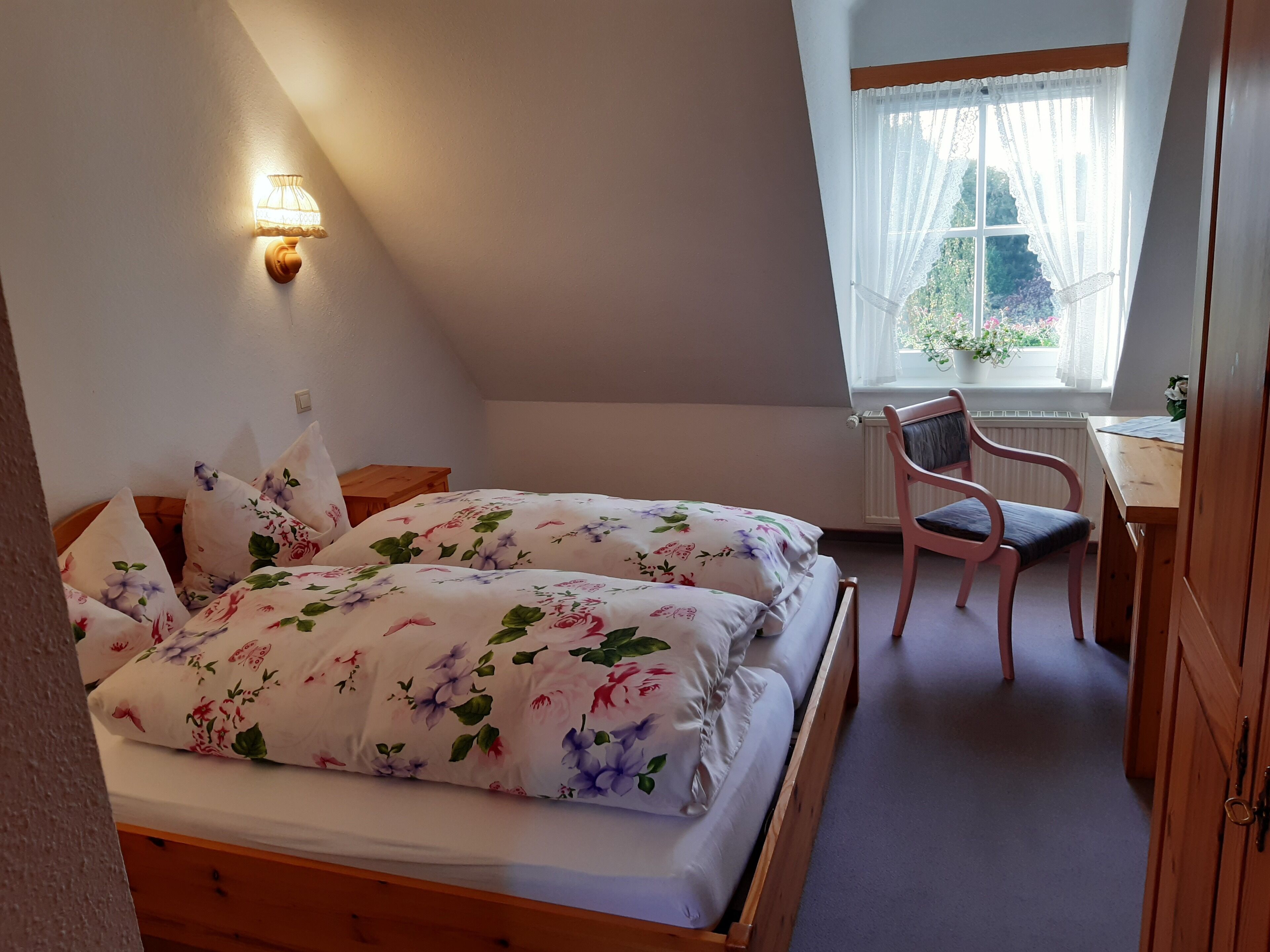 A bedroom with a bed, a desk, and a chair.