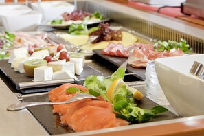 Enjoy a sumptuous spread of assorted dishes, including salmon and cheese, served in a casual dining area.