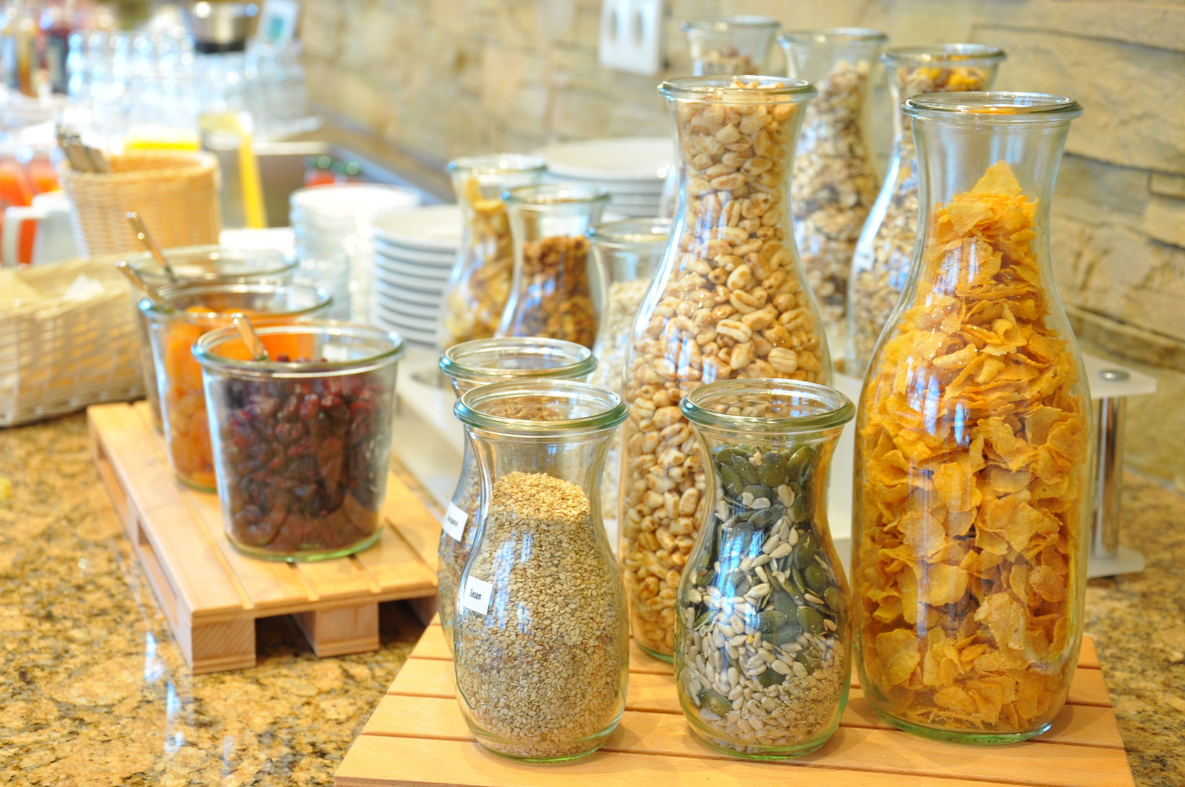 Diversos alimentos en recipientes de vidrio sobre una tabla de madera.