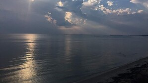 A beach with calm waters and a cloudy sky. - The Baywood Bed & Breakfast (Cape Charles)