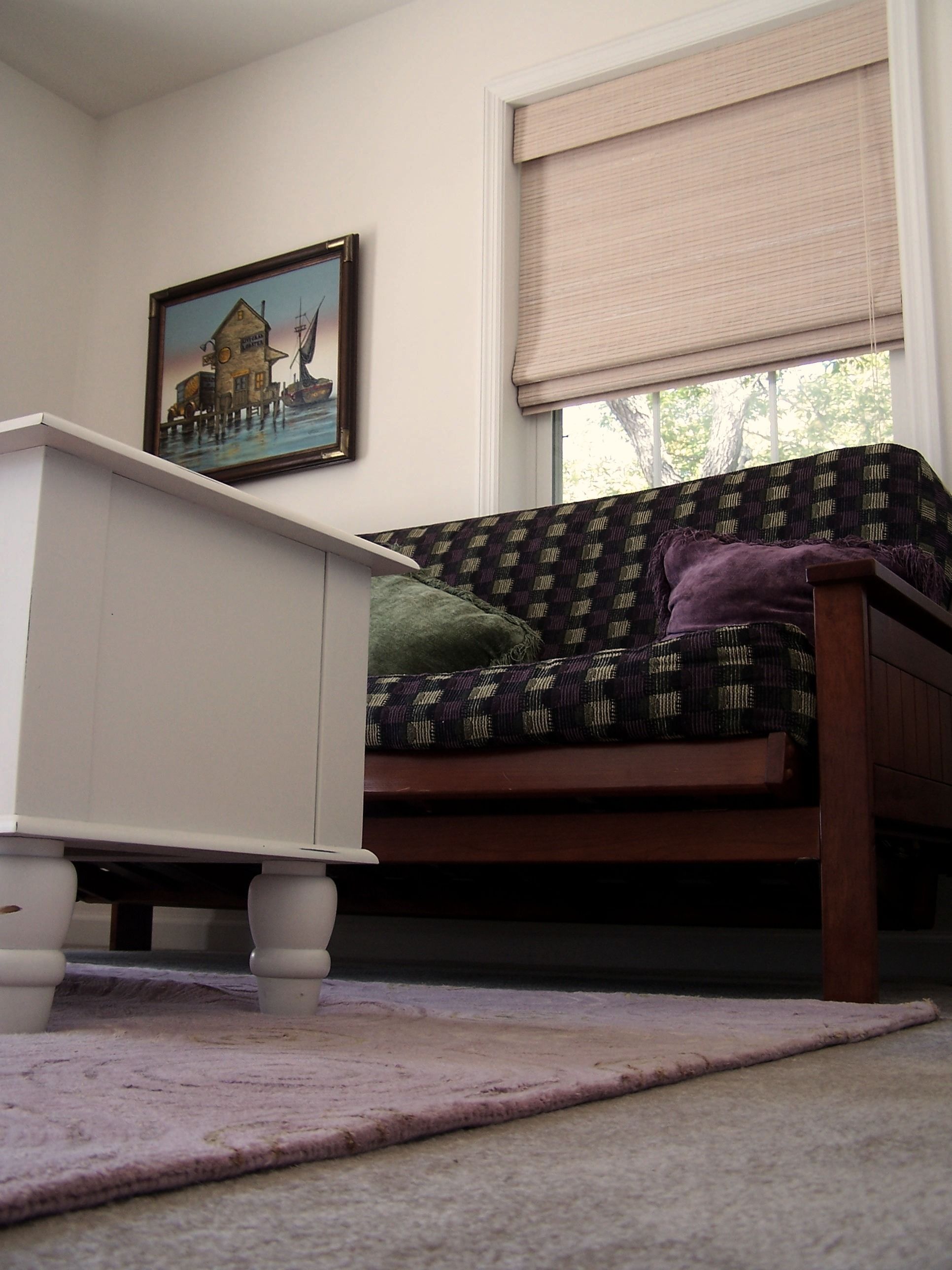 A bedroom with a bed, a dresser, a window with blinds, and a painting on the wall.