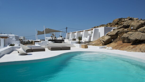A modern pool area with white architecture and a clear blue pool. - Ruby Suite (Mykonos)