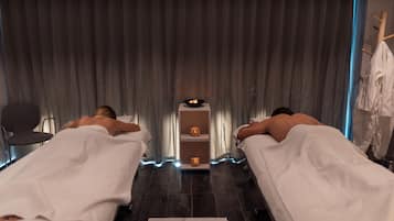 Two beds and a small table with a bowl of fruit, perfect for a restful stay.
