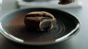 A dessert on a plate with a spoonful of powder beside it.