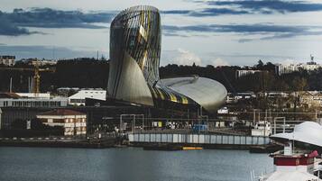 A waterfront view with a distinctive modern building and a boat docked nearby.