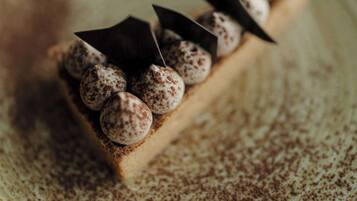 Un postre en un plato con un toque de cacao en polvo.
