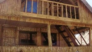 A wooden building with a balcony and a staircase leading to an upper level. - Paniman Bay lodge (Caramoan)