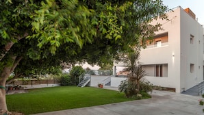 A modern building with a flat roof, a concrete patio, and a well-maintained lawn. - Steliana 2 (Malevizi)