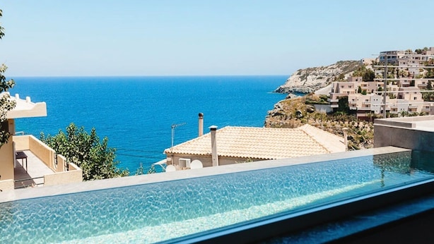 A clear blue sea with a swimming pool in the foreground and buildings in the background. - Steliana 2 (Malevizi)