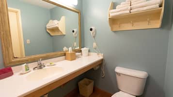 A bathroom with a sink, mirror, towel rack, and toilet.