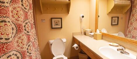 A bathroom with a toilet, sink, and towel rack.