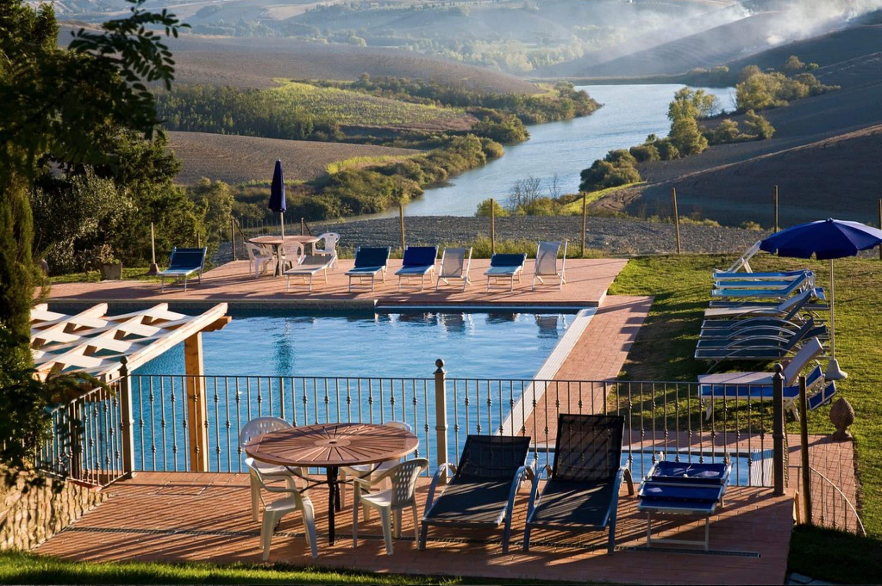 Una piscina al aire libre de temporada, sombrillas