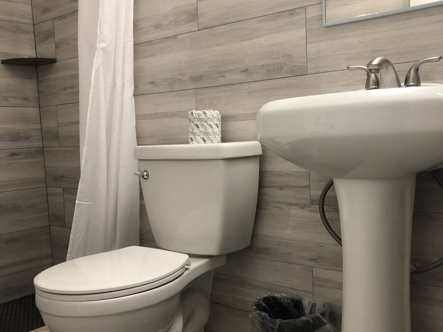 Ein Badezimmer mit Toilette, Waschbecken und einer Duschvorhang.