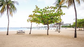 On the beach, white sand, sun loungers, beach umbrellas