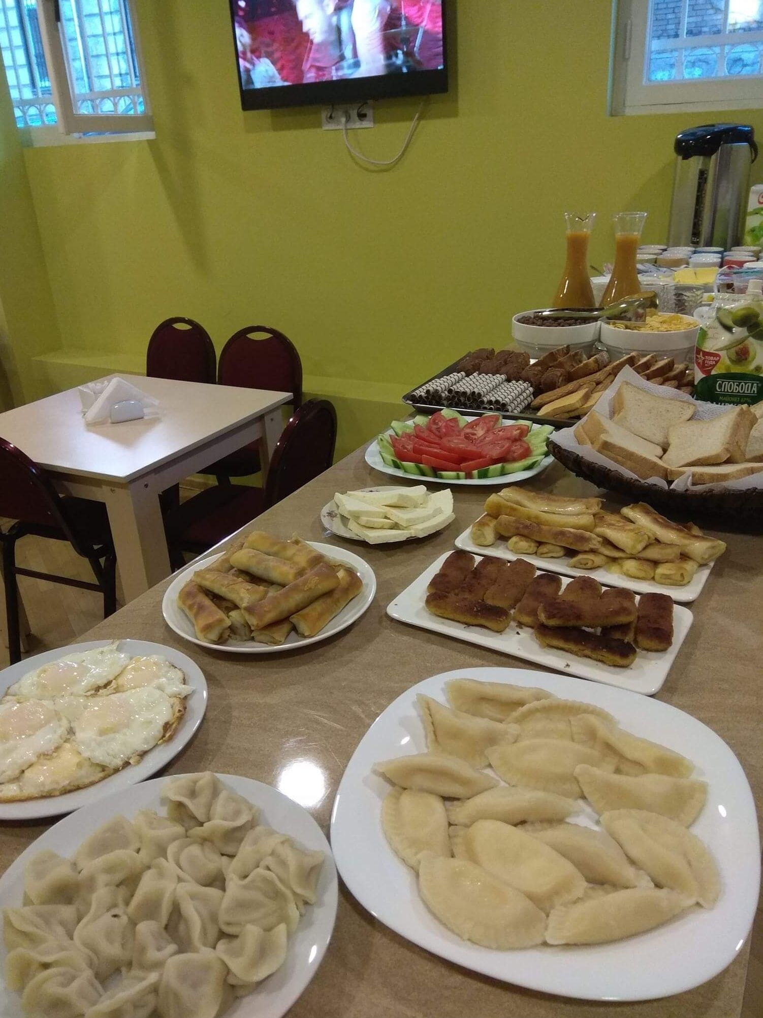 Een ontbijtbuffet met diverse gerechten, waaronder eieren, gebak en fruit.