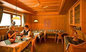 L’intérieur d’une cabane en bois comprend un coin repas, un banc et un petit autel.