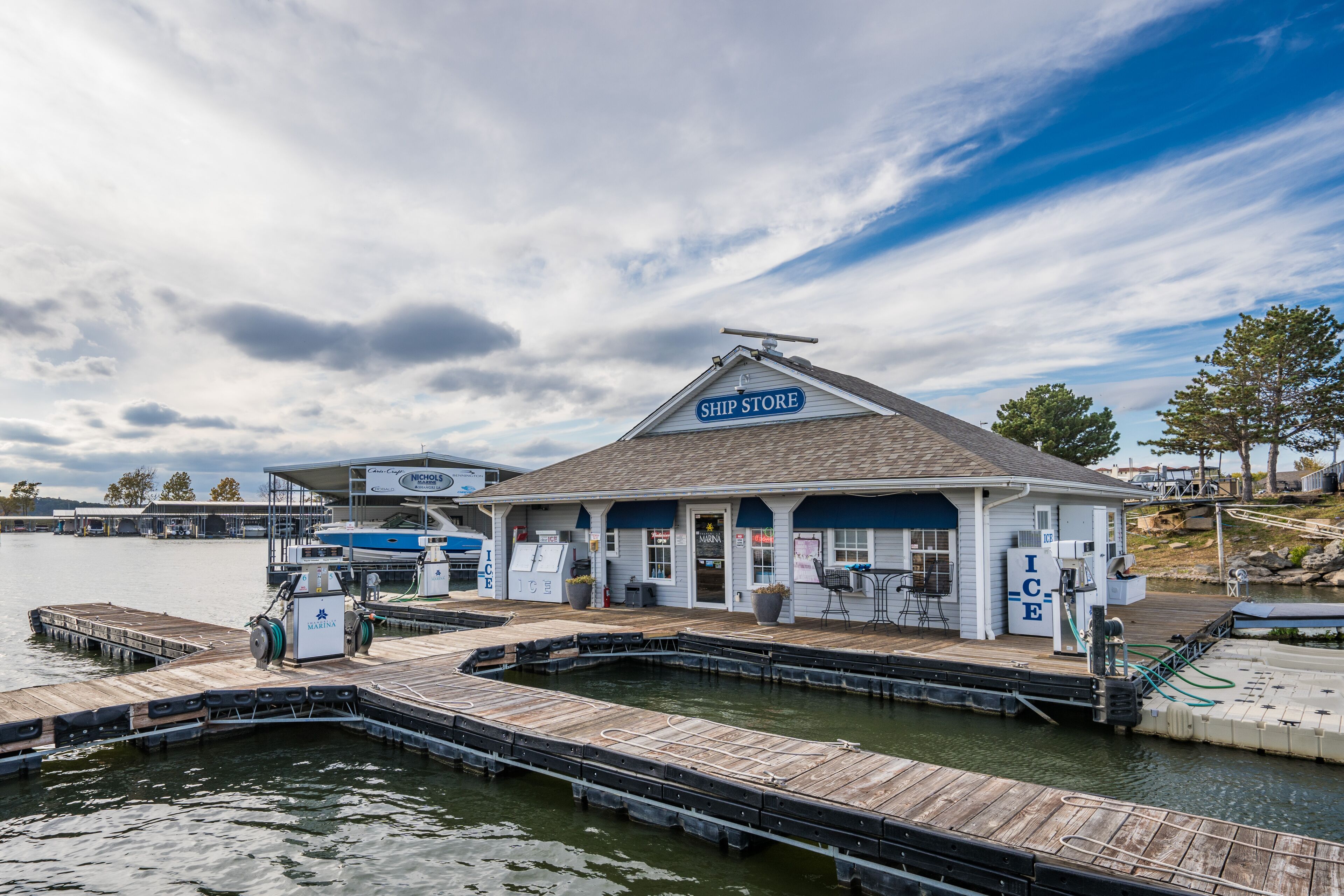 A waterfront ship store with a dock and a small building with a sign that reads "SHIP STORE".