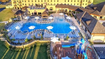Una piscina techada, una piscina al aire libre, sombrillas