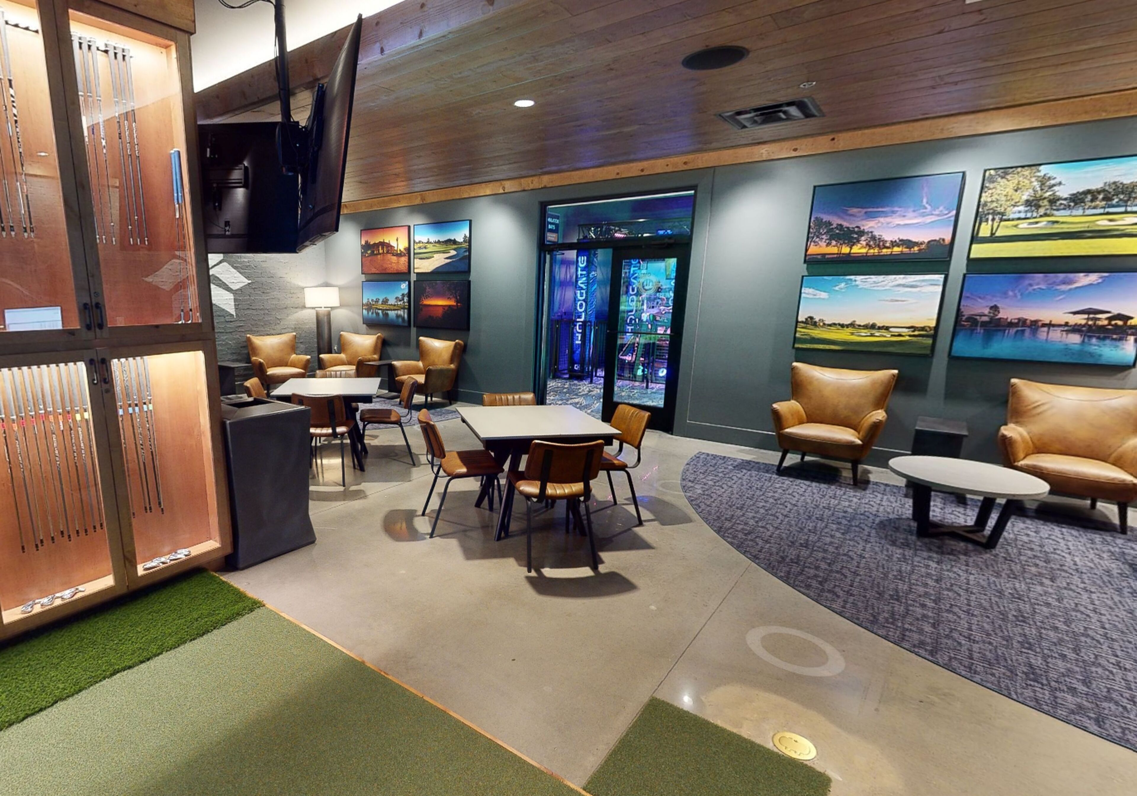 A modern hotel lobby with a reception desk, seating area, and wall-mounted artwork.