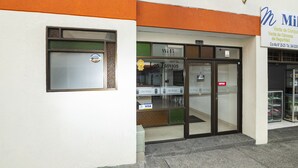 L’entrée d’un hôtel, avec une porte en verre, un panneau Visa et un panneau indiquant la présence d’une caméra de surveillance.